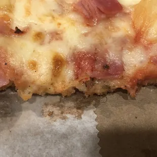 Hawaiian pizza with hair embedded in the cheese