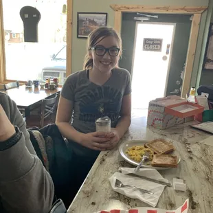 a woman sitting at a table with food