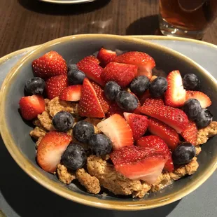 a bowl of oatmeal with strawberries and blueberries