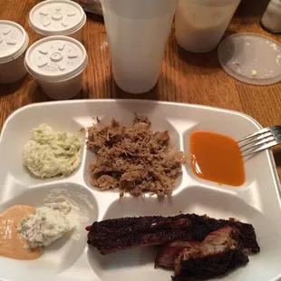 Clockwise from top left: slaw, pulled pork, house BBQ sauce, ribs, miles sauce (with a little potato salad)
