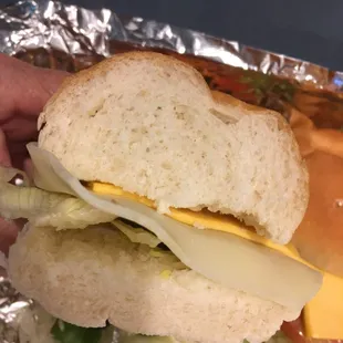 Veggie sandwich with two super thin slices of cheese on weird puffy, thick, flavorless bread.