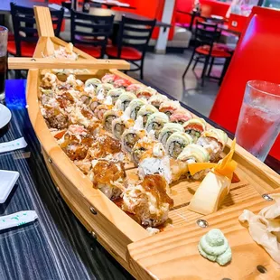 a long wooden boat filled with sushi