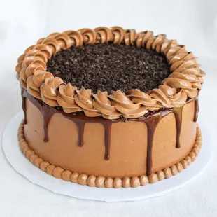 a chocolate frosted cake on a white plate