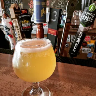 a glass of beer on a bar