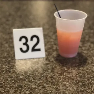 a plastic cup with a straw and a number 32