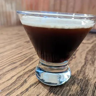 a glass of coffee on a table