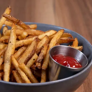 a bowl of french fries with ketchup
