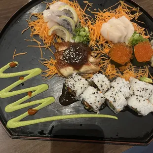 Sashimi plate featuring mackerel, eel, salmon roe, and an eel maki roll.
