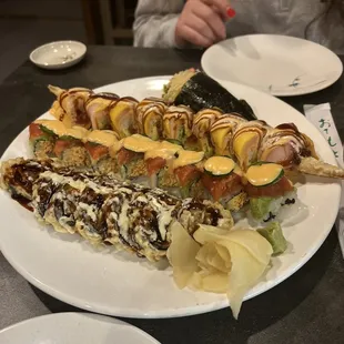 a plate of sushi with a woman in the background