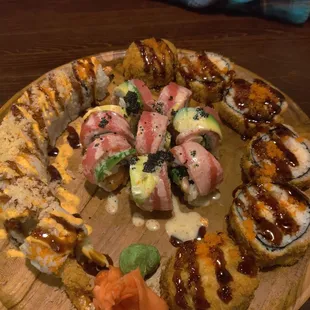 a variety of sushi on a wooden plate