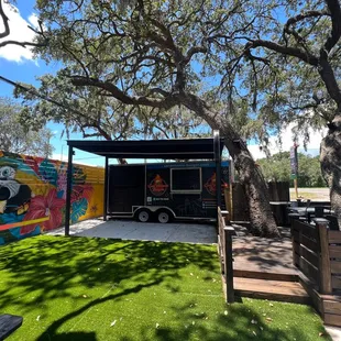 a food truck parked under a tree