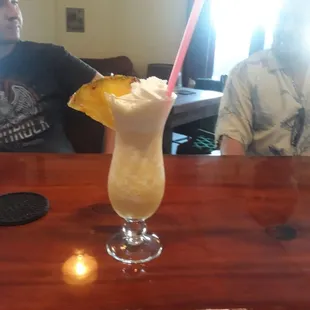 a man sitting at a bar with a drink in front of him