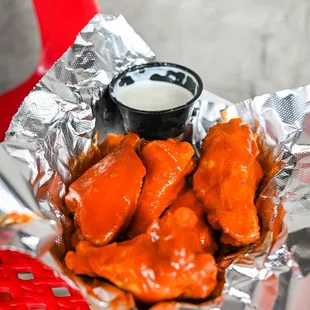 a plate of chicken wings with a dipping sauce