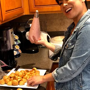 Filling the mini cream puffs by the Caker