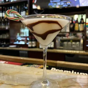 a candy cane in a martini glass