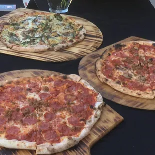 three pizzas on wooden boards