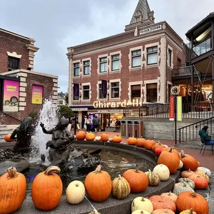 a fountain with pumpkins in front of a building