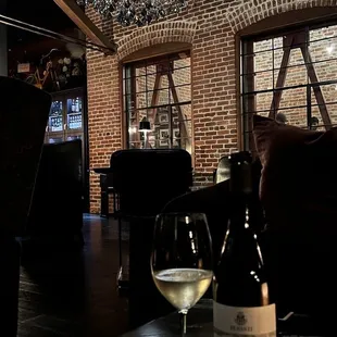 Exposed brick and giant elaborate chandelier in the main seating area. Also pictured: 2020 Benanti Etna Bianco.