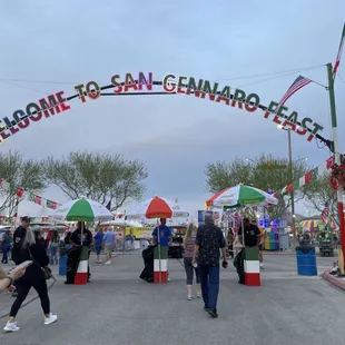 a crowd of people walking under a banner