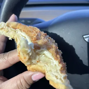 Partially eaten Cheese bomb - so yummy! It's a super soft pandesal with a sweet crumble on top filled with cream cheese.