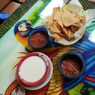 a table with chips, salsa, and guacamole