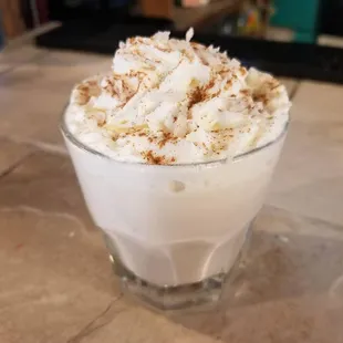 a cup of coffee with whipped cream and cinnamon sprinkles
