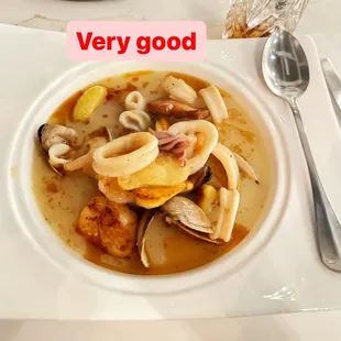 a bowl of soup with a spoon and fork