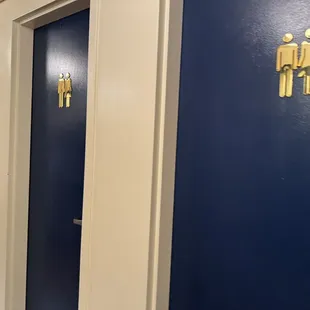 a row of blue and white restroom doors