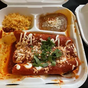 Enchiladas with red sauce and rice and beans
