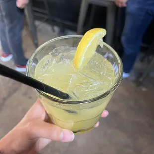 a person holding a glass of lemonade