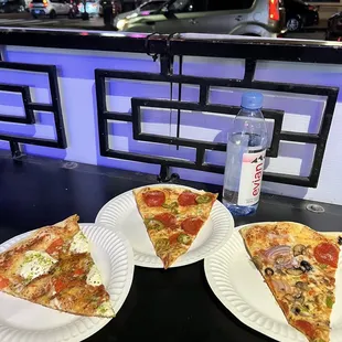 two slices of pizza on paper plates