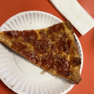 a slice of pizza on a paper plate