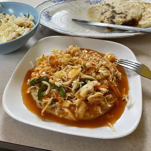 Chicken pupusa smothered in curtido and tomato sauce.