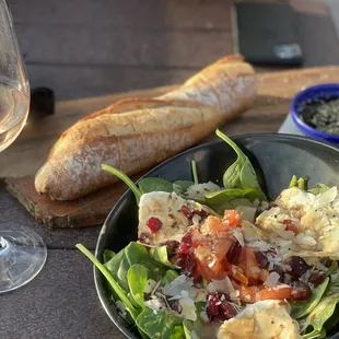 a bowl of salad and a glass of wine