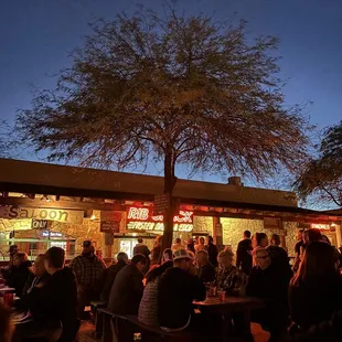 a large group of people sitting outside a restaurant