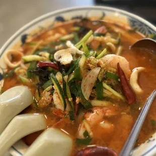 a bowl of soup with chopsticks