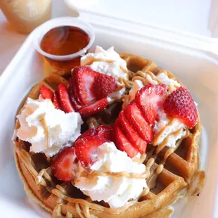 Gluten free waffle with strawberries, whipped cream, and peanut butter