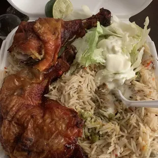 chicken, rice, lettuce, and sauce in a styrofoam container