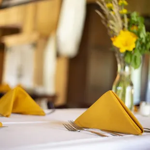 a table setting with yellow napkins