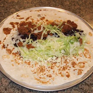 a tortilla with meat and lettuce