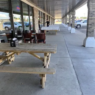 a row of picnic tables on a sidewalk