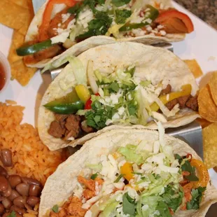 three tacos on a white plate