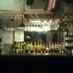 a bar with wine glasses on the bar
