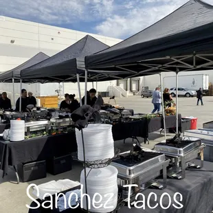 a group of people standing under a tent