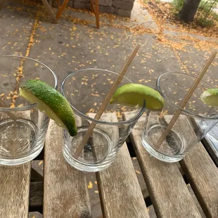 a row of shot glasses with lime slices