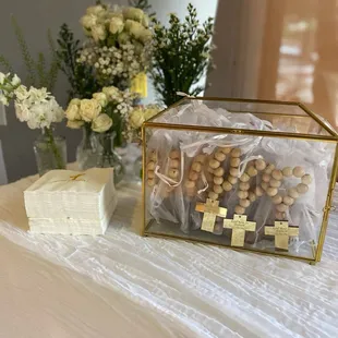 a box of rosary beads and a box of flowers