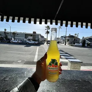a person holding a bottle of orange juice