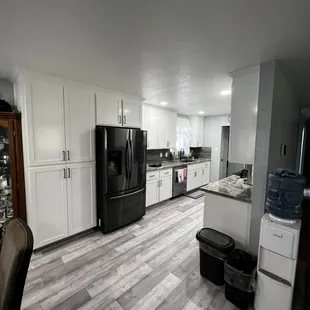 a kitchen with white cabinets and black appliances