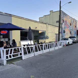 people sitting at tables outside of a restaurant