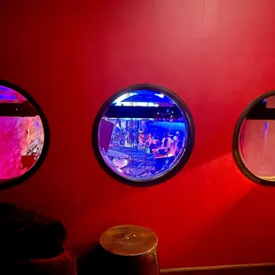 three round windows in a red room